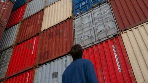 image of a person looking up the stack of containers for the article "IS SPENDING TIME ON YOUR CRM DATA WORTH YOUR ADMIN BURDEN?"