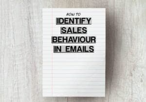 white piece of paper on grey wooden table with the words identify sales behaviour in emails edited on top