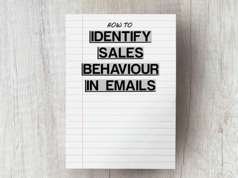 white piece of paper on grey wooden table with the words identify sales behaviour in emails edited on top