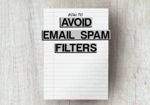 piece of lined paper on grey wooden table with the words how to avoid email spam filters edited onto photo