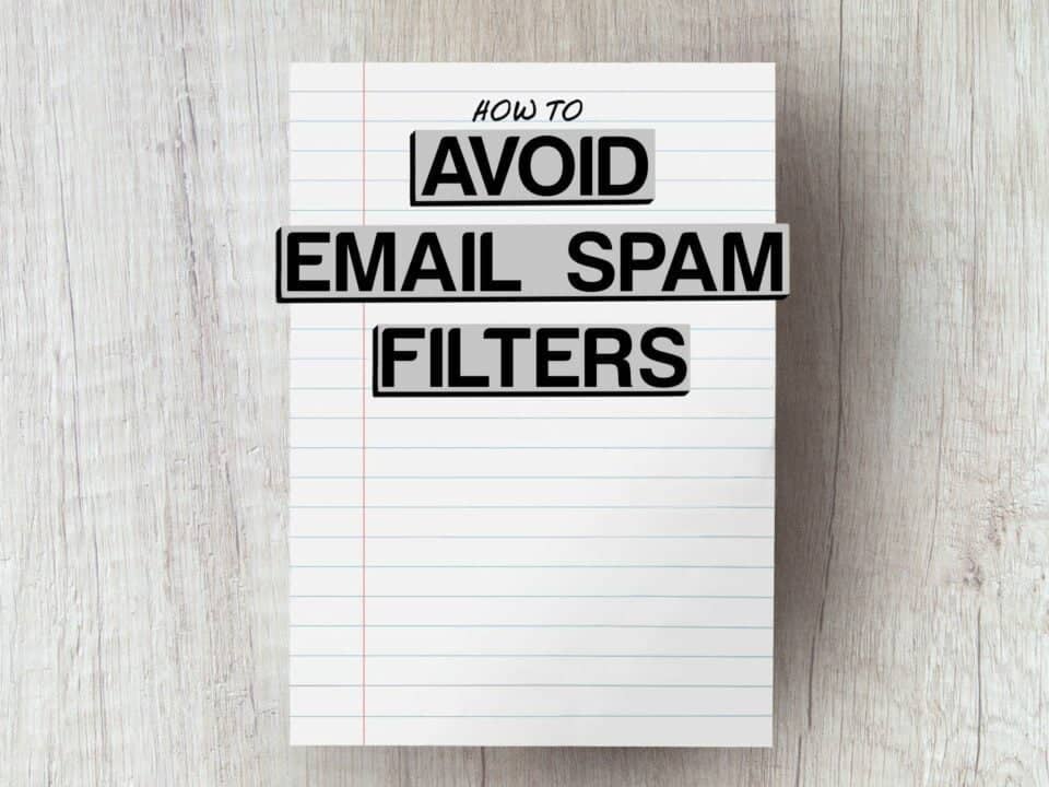 piece of lined paper on grey wooden table with the words how to avoid email spam filters edited onto photo