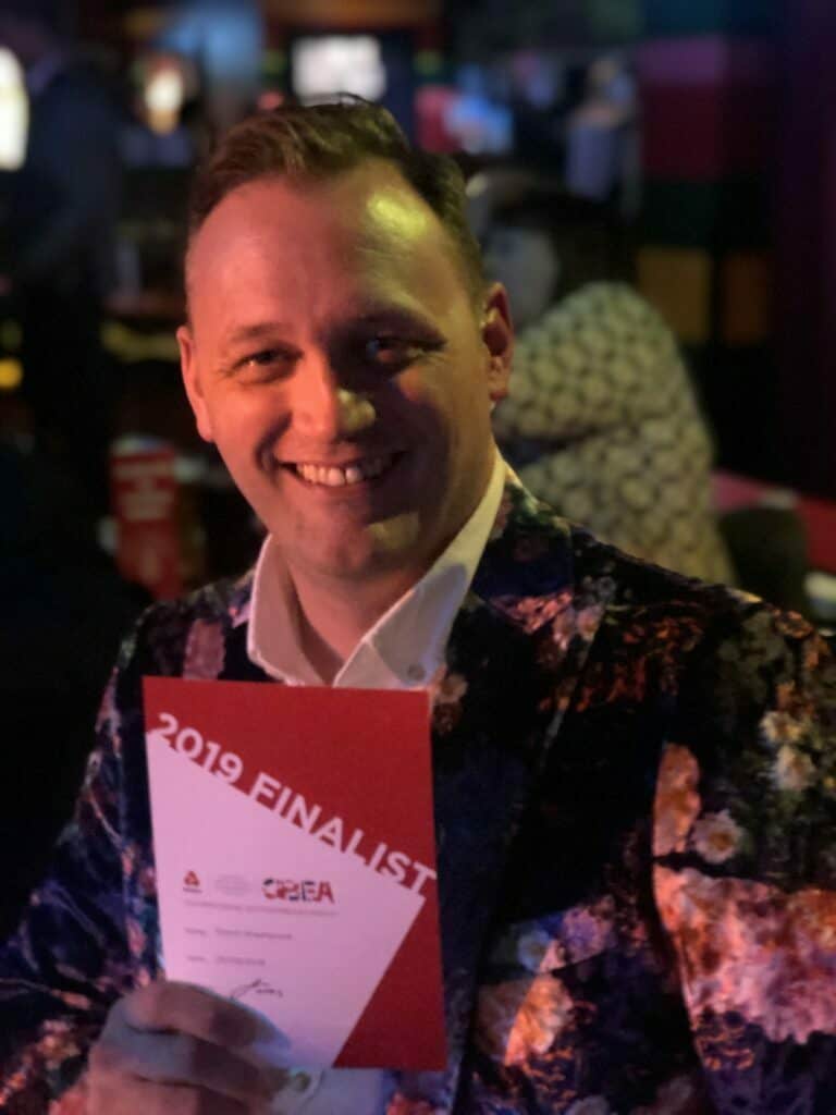 image of Simon Washbrook founder of popcorn crm holding GBEA Finalist 2019 card for the article How the perfect Jacket led to a perfect Partnership with the GBEA