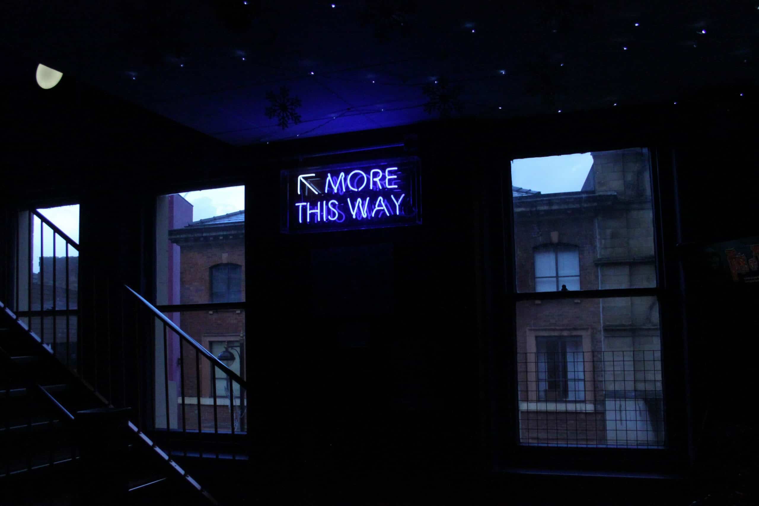 purple neon sign in brick building with the words 'more this way' for email capacity upgrade your popcorn package article