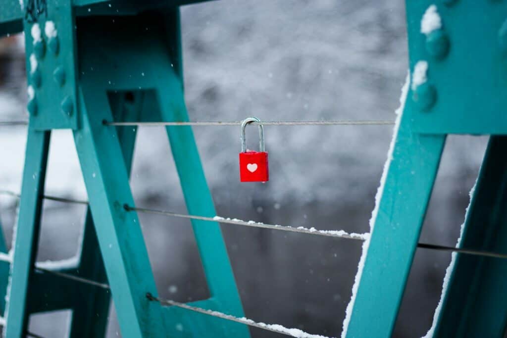 red lock with a white heart locked on a bridge railing representing customer retention