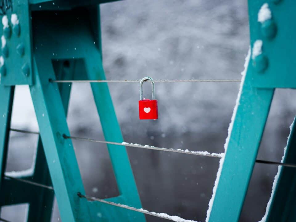 red lock with a white heart locked on a bridge railing representing customer retention