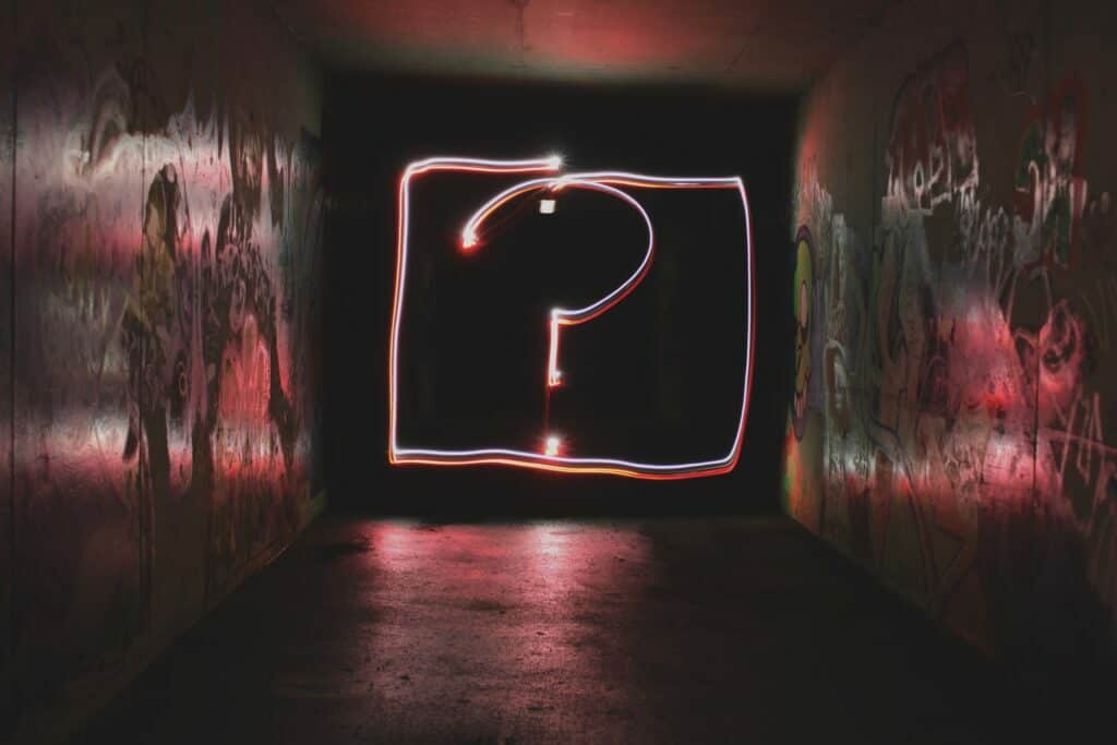 image of a lit-up neon question mark in a square in a dark corridor with graffiti on the walls for the article types of loyalty programme