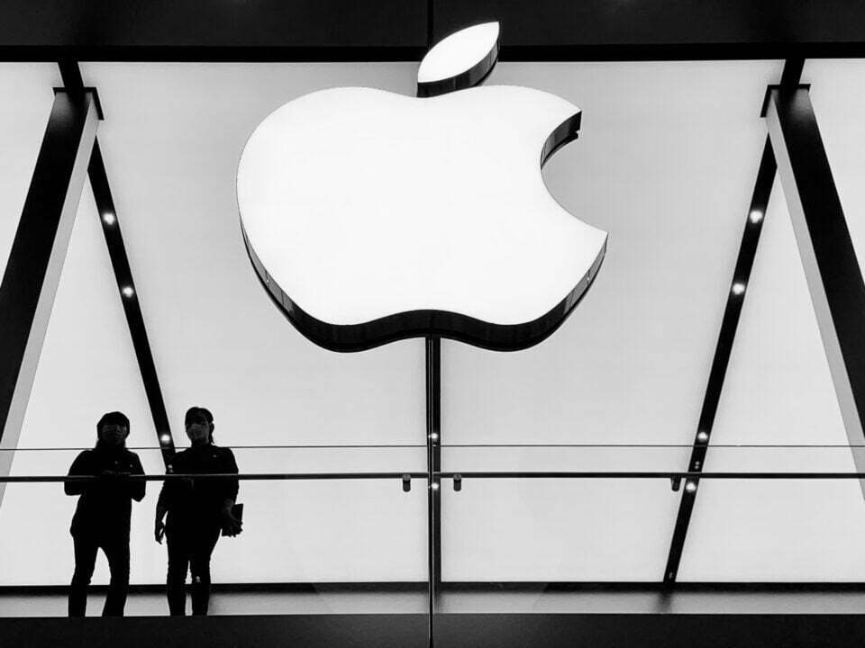 silhouette of people standing below white apple logo ios 15