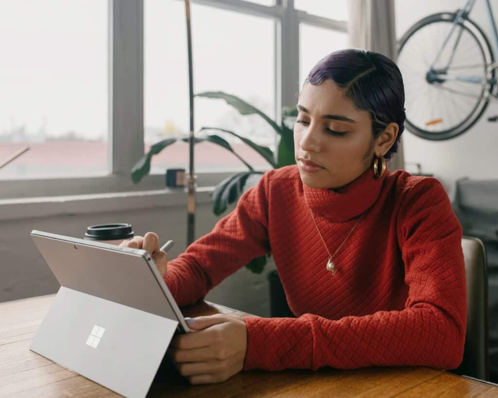 person in red jumper using touchscreen tablet concentrating for sales pipelines ras article