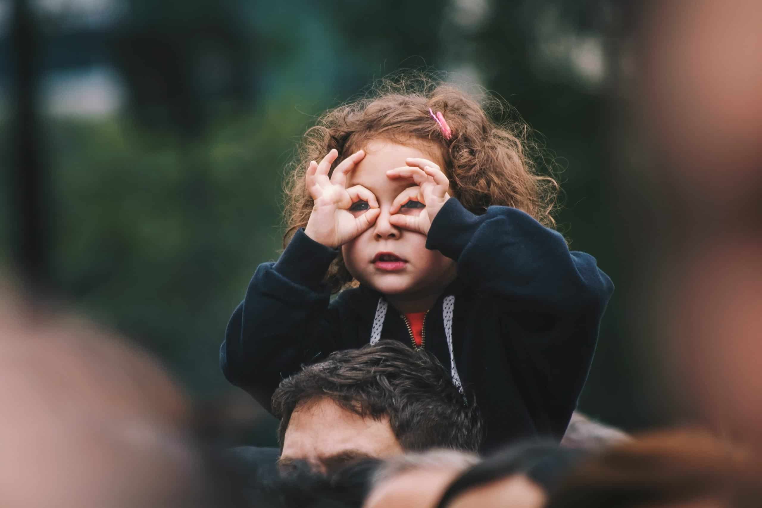 girl making binoculars with her hands for small business article