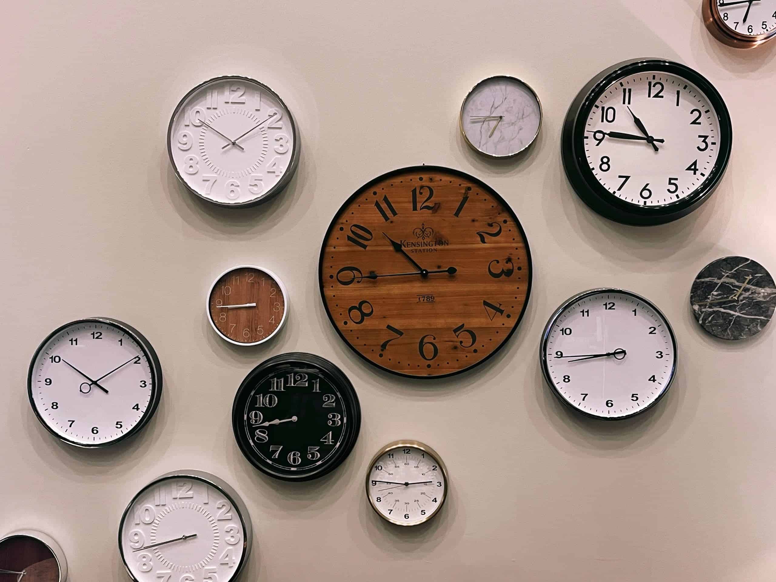 brown analogue clocks in different sizes on wall for investing time in lead management software article