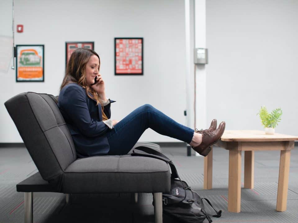 woman sitting on black office chair on phone for strengthening customer communications article