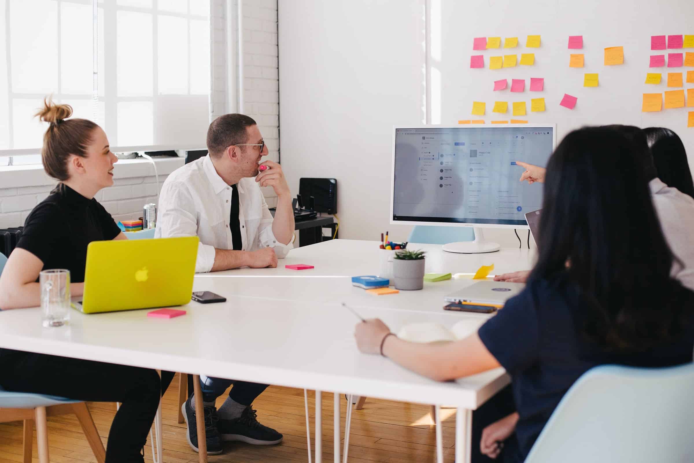 people gathered around a table looking at a monitor for business meeting for segmenting customers article