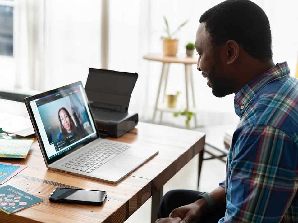 man in plaid shirt talking to woman over zoom call for best salesman/salesperson article