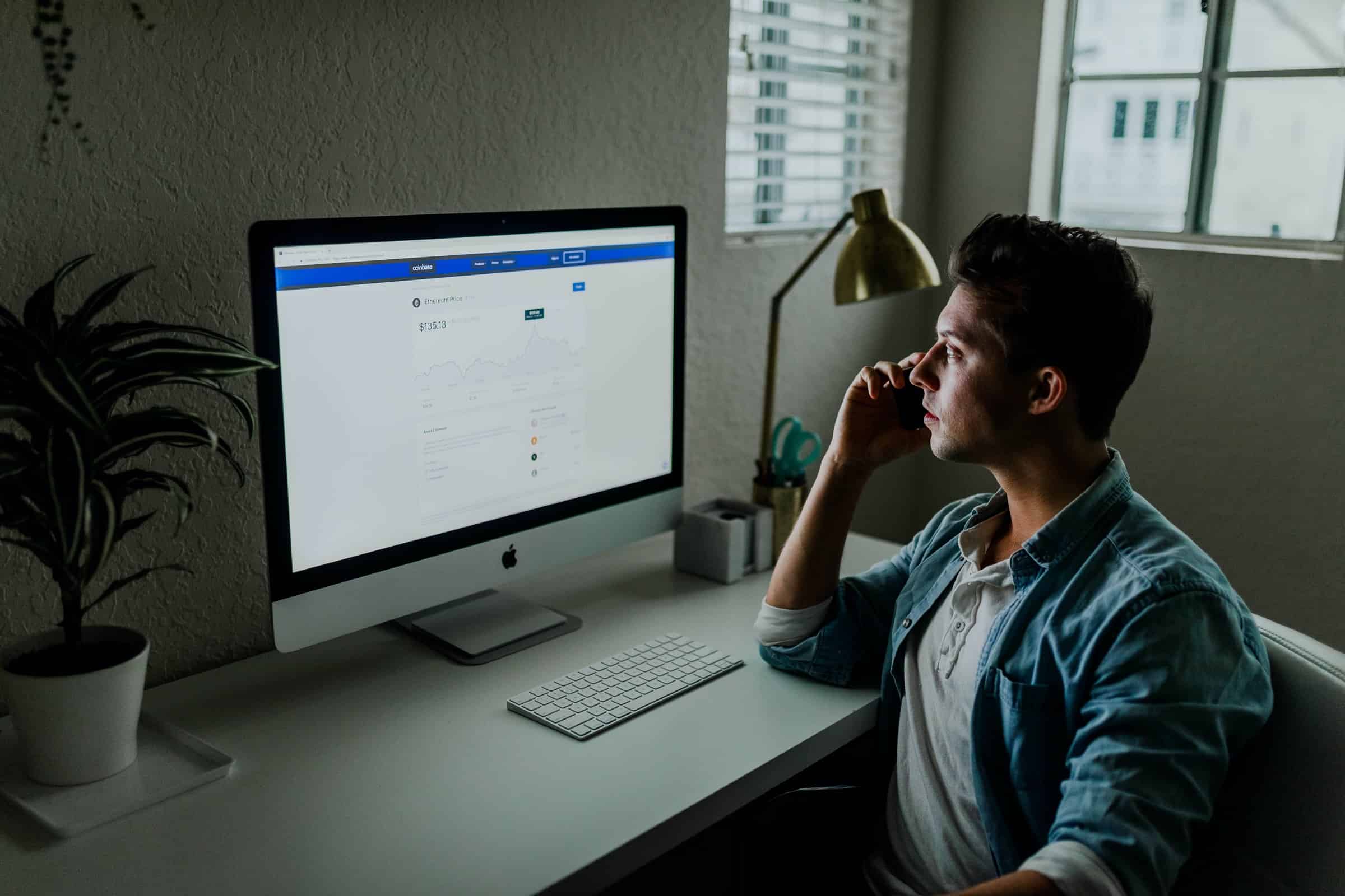 man looking at business report on monitor in darkly lit room for prospect list multiple spreadsheets article