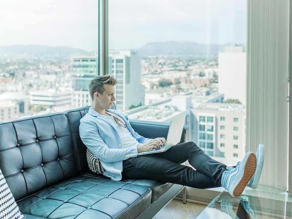 man sitting on sofa while using a laptop for simple prospecting article