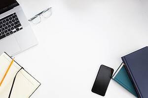 office work tools on the white desk for benefits of using crm software for small business article