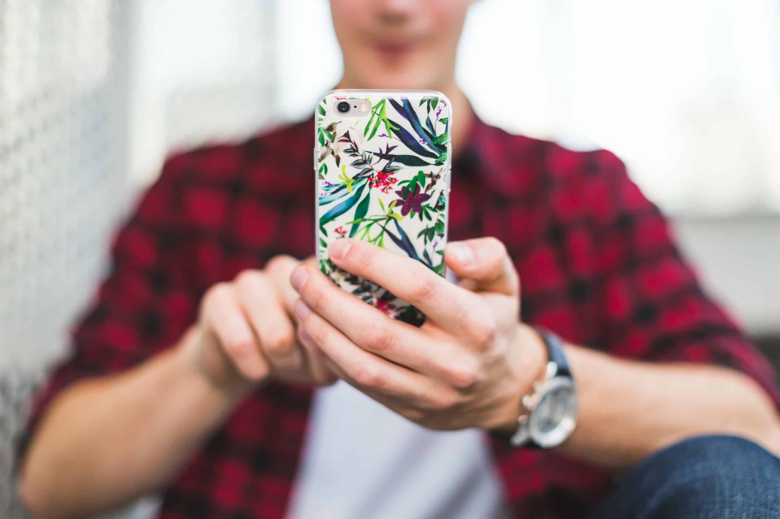 young man texting on iphone for benefits of using a crm software for small business article