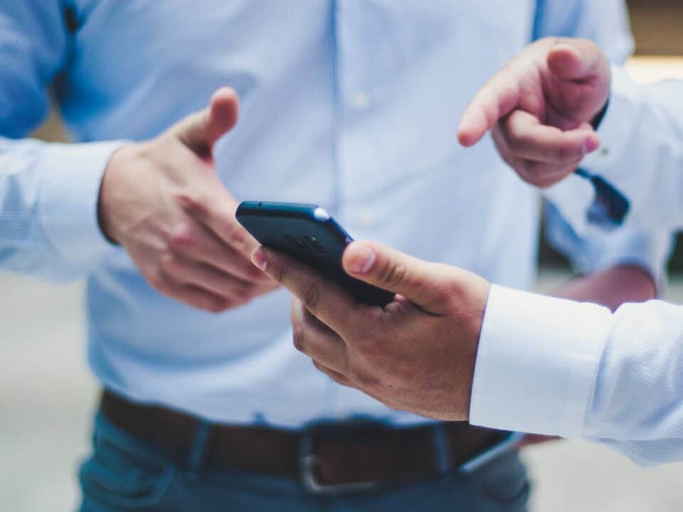 two people in suits pointing at phone for buying cycle article