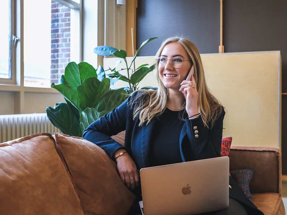 woman in blue jacket making a phone call on sofa for lost customer article